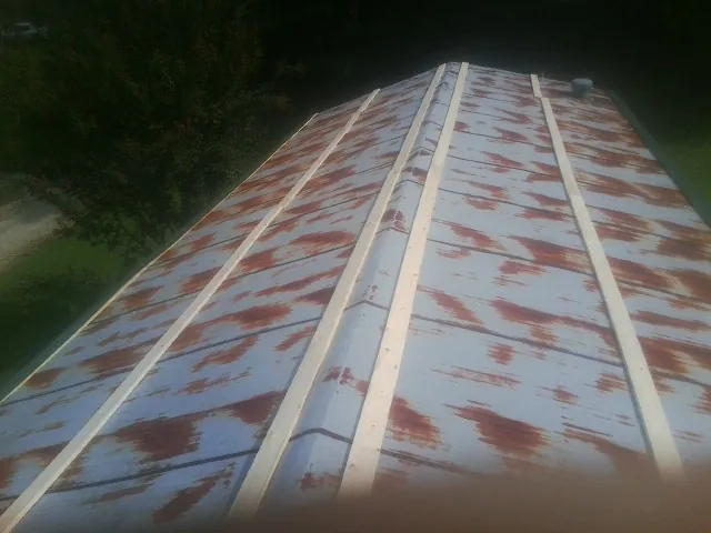 Rusted metal roof panels with new wood purlins before replacement — Storm Damage Roof Repair in Tiller by Roofing Brothers