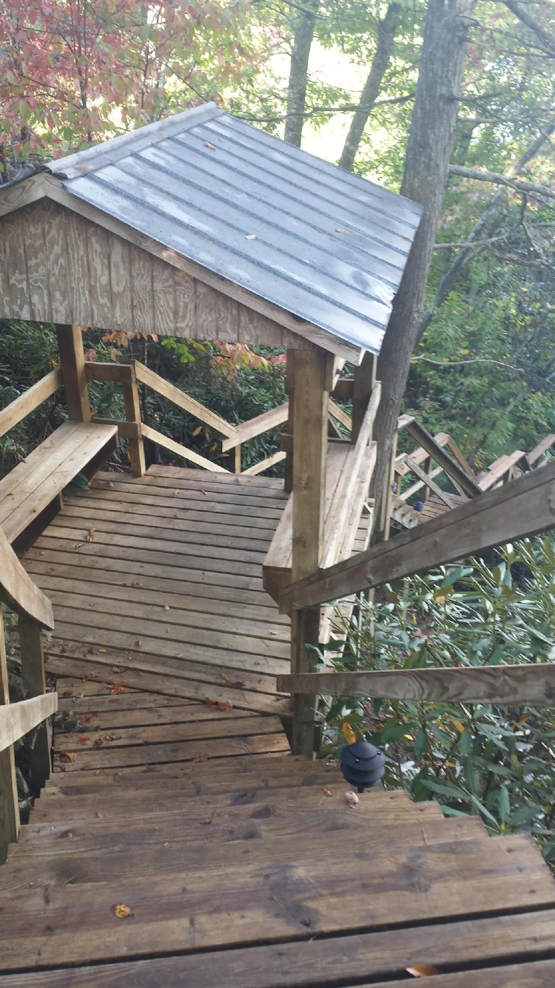 Metal roofed shelter over wooden steps on a wooded walkway — Skylight Repair & Installation work by our crew in Tiller