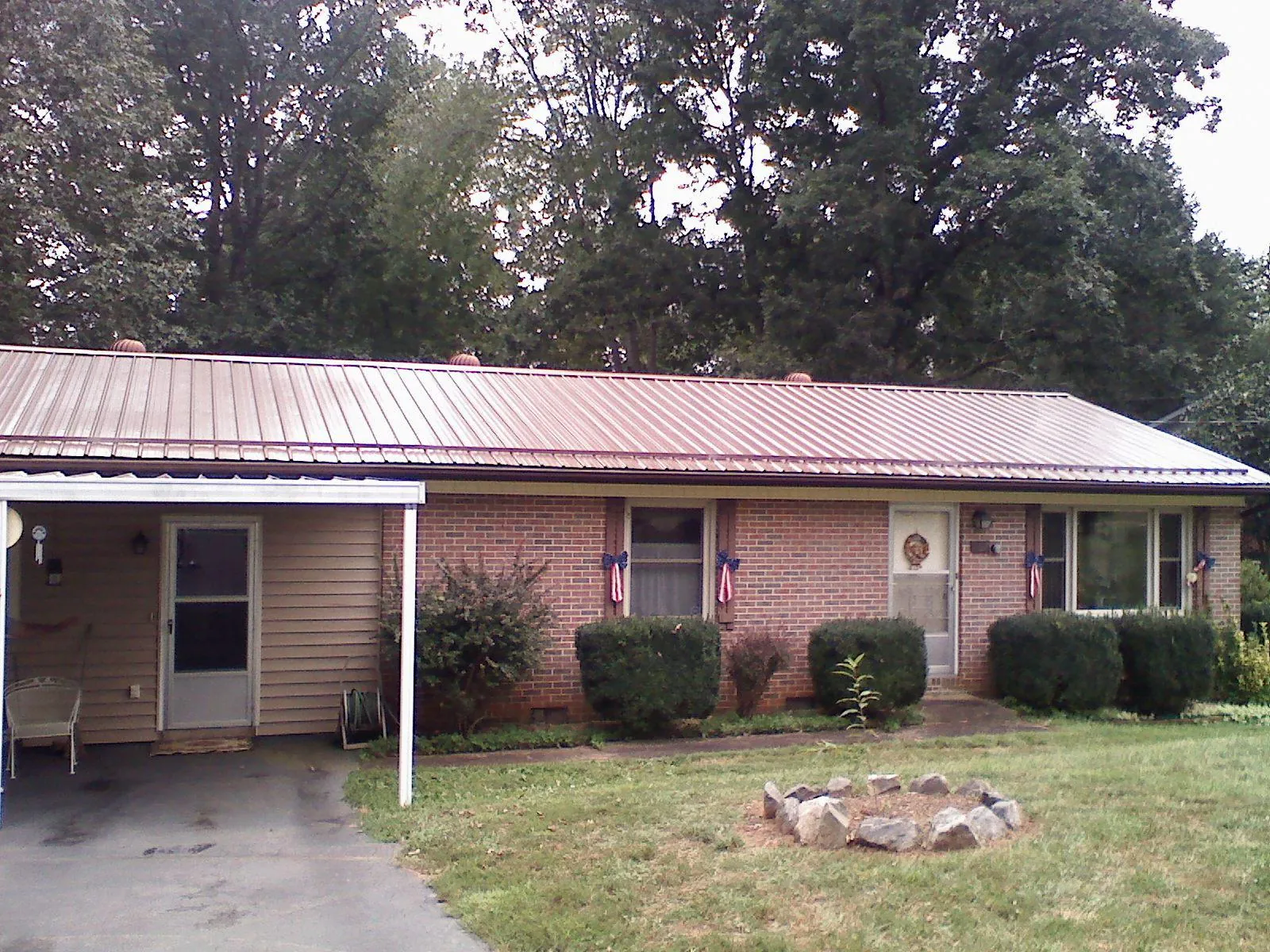 Bronze metal roof and carport on a brick ranch home — Roof Repair work by our crew in Tiller